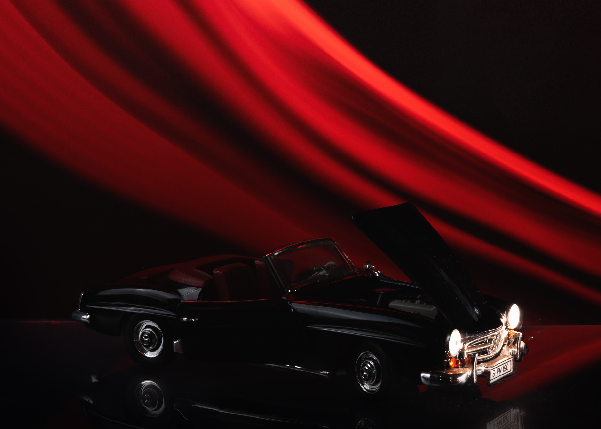 A cinematic photograph of a die-cast vintage convertible
